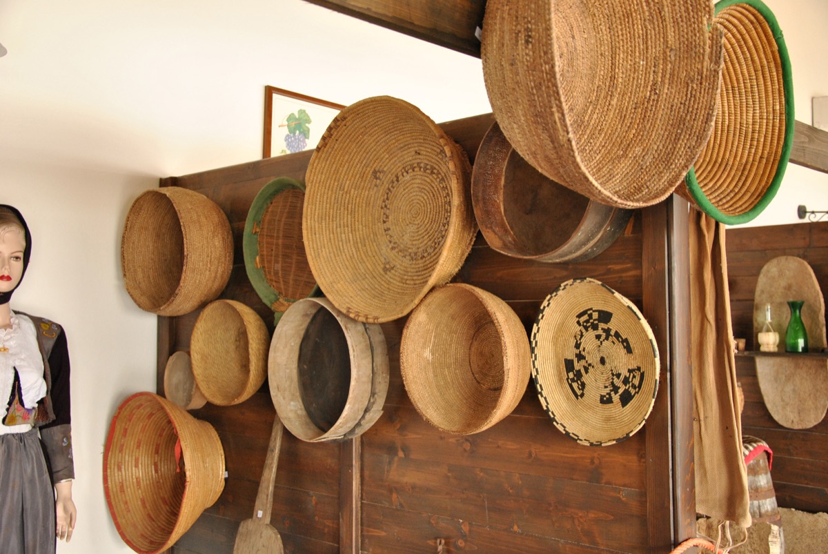Museo etnografico con cestini in giunco e costume sardo